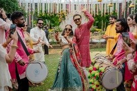 Bride and groom dancing at their sangeet with dhol players