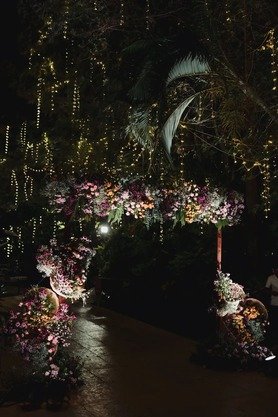 Floral mandap arch decorated with fairy lights at night