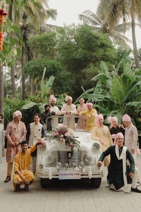 Groom and groomsmen in turbans posed with a vintage wedding car