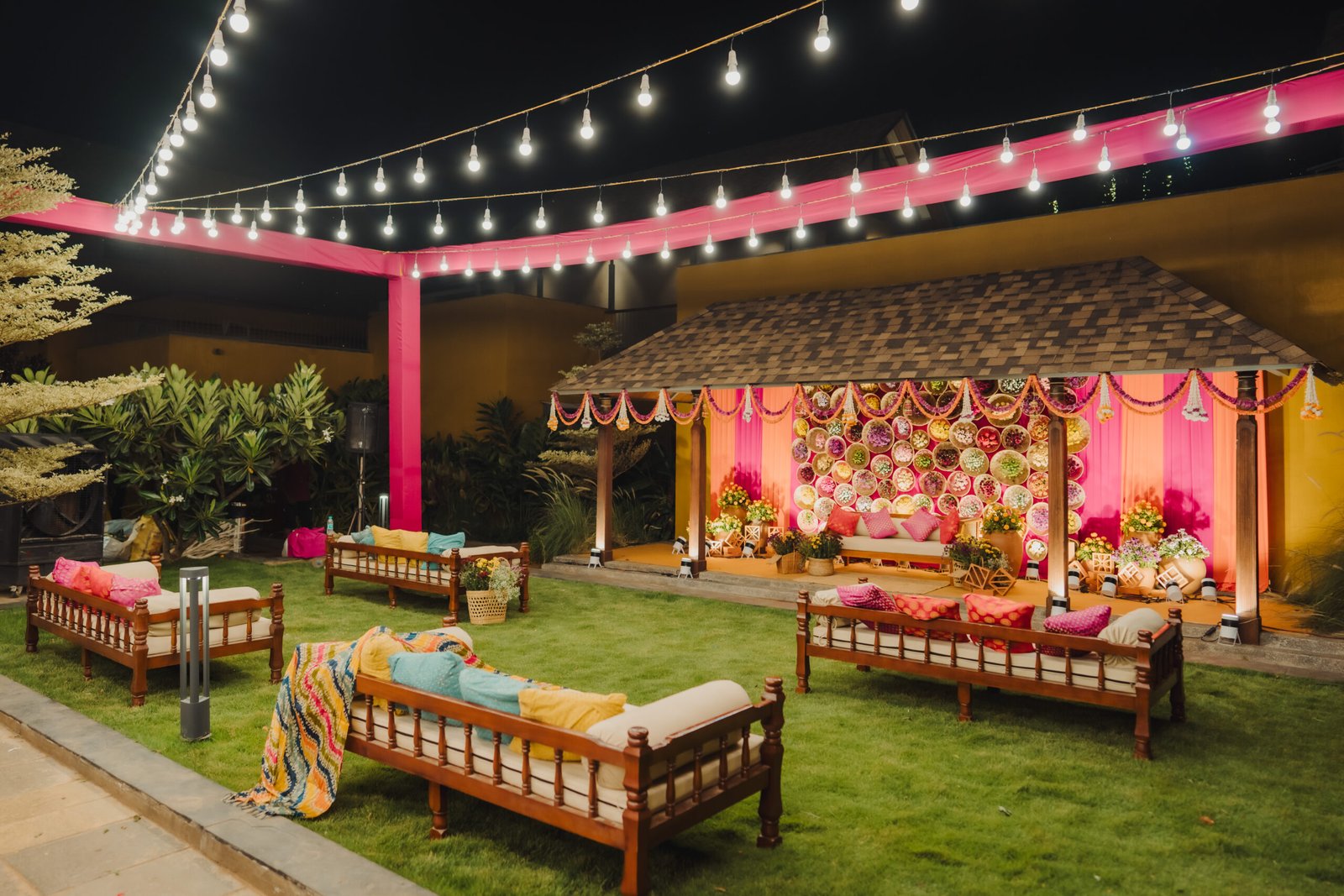 Luxury outdoor wedding décor with white drapes, marigold garlands and floral stage setup in Bangalore